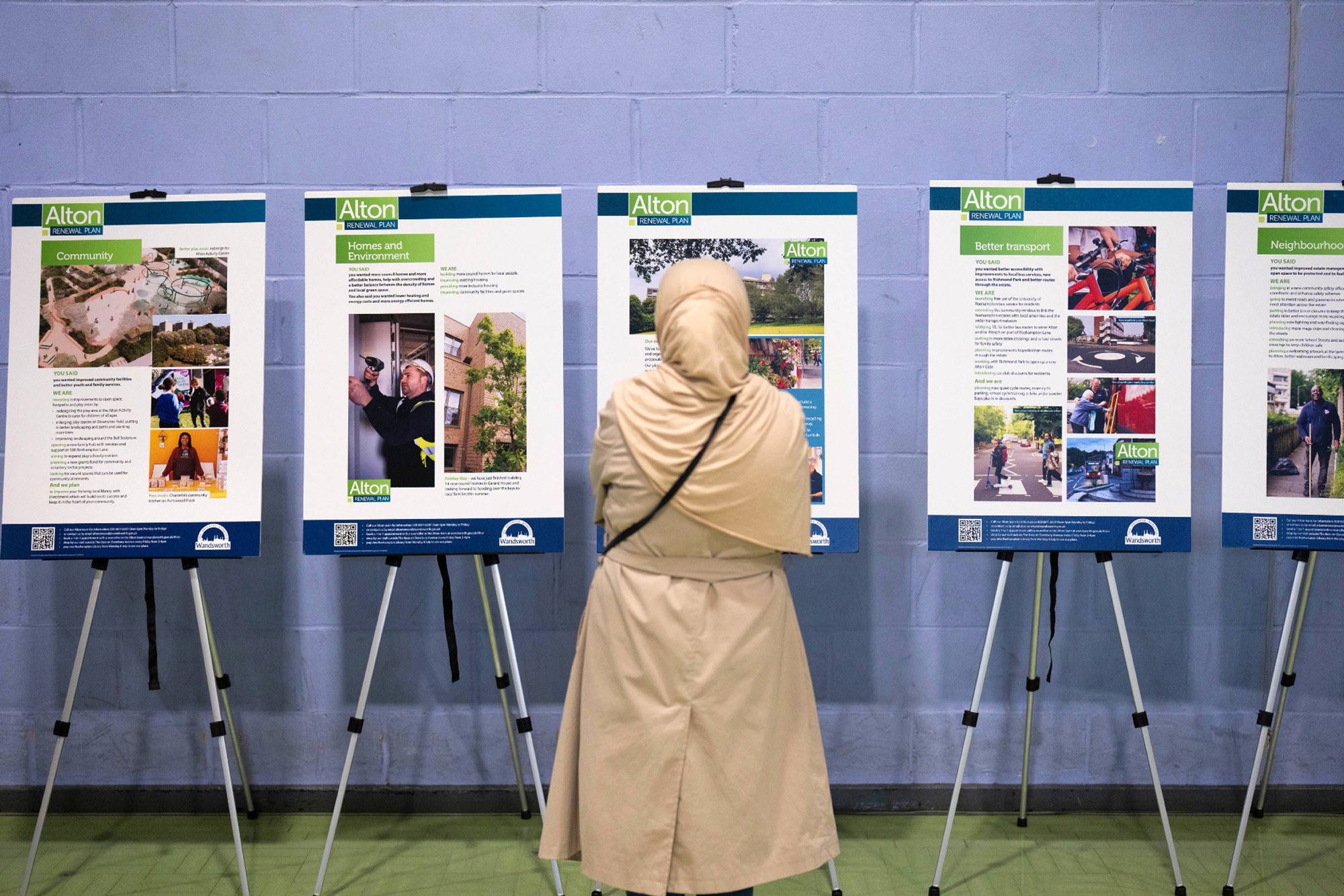 A member of the public is pictured, with her back to the camera, viewing exhibition panels at the Alton community drop-in event