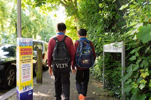 Two children are pictured walking along a pavement towards Heathmere School