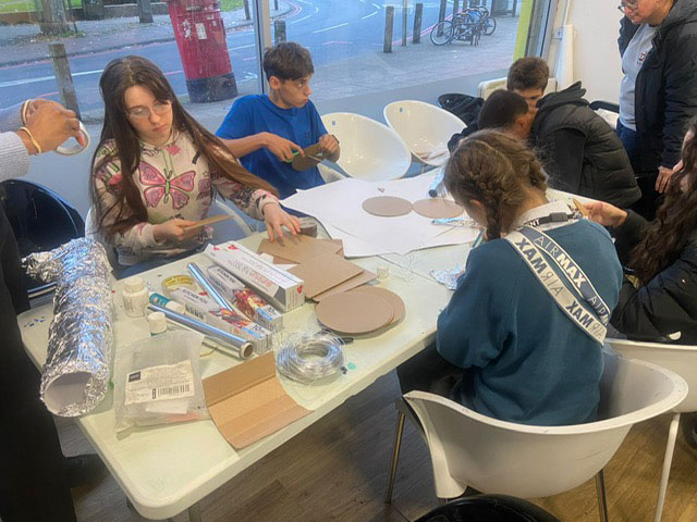 Young people are pictured working at a table.